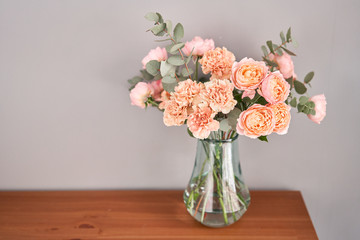 Flowers in glass vase on wooden table. Fresh cut flowers for decoration home. Delivery flower.