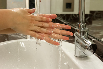 woman washing hands in sink. Dangerous touch concept, prevent spread of virus, wash your hands with soap