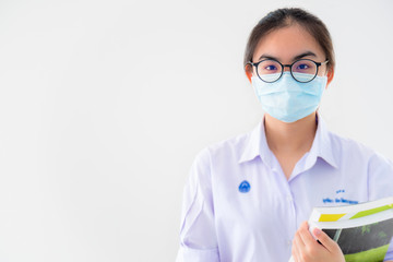 Studio portrait student Asian young woman wears glasses and mask to protect against Coronavirus, Thailand girl people on white background concept of health protection from virus outbreak of Covid 19