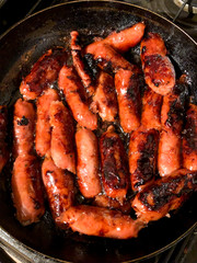 Longanisa, a type of Filipino sausage cooking in a frying pan.