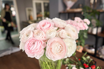 Persian buttercup. Bunch pale pink ranunculus flowers. Vase on vintage wooden table. Floral shop concept . Flowers delivery.