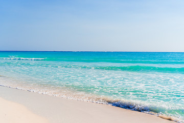 Fototapeta na wymiar Idyllic tropical beach with white sand, turquoise ocean water and blue sky on Caribbean island