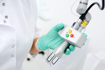 doctor cosmetologist dermatologist holds an innovative device for skin rejuvenation, removal of...