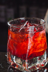 alcoholic cocktail with ice on a dark blurry background