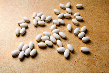 Fototapeta na wymiar vitamin D pills lie chaotically against a sand countertop