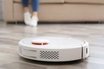 Woman resting while robotic vacuum cleaner doing her work at home