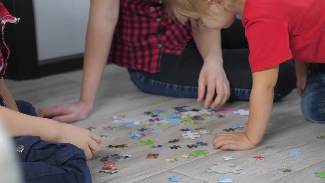 little daughter girl happy family collection puzzles lifestyle teamwork. development of fine motor skills and thinking. daughter and girl with mom a collect mosaic puzzles