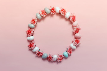 Creative decor wreath arranged in circle with Easter eggs and pink roses. Photo on pink background and copy blank space in the center.