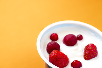 yogurt with berries - strawberries, cherries, cranberries, close-up on a bright background. healthy food, light breakfast. a mixture of vitamins and antioxidants for health care. dairy products.