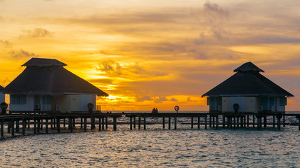 Sunset on tropical island, water villas resort
