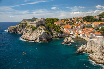 Fototapeta na wymiar Kayakers on the coast with city walls of Dubrovnik, Croatia