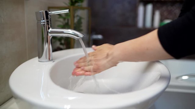 Woman washing hands with tap water, soap and disinfectant Removing dirt, germs, viruses and bacteria