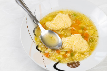 Homemade chicken soup served on the plate with spoon