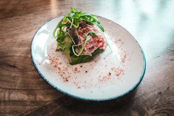 Beef steak tartare with avocado cream and onions. French cuisine. Top view. Copy space.