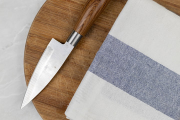 Flatlay above kitchen dishcloth and knife on the wooden board
