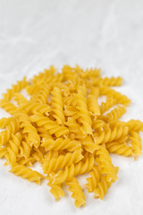 Raw pasta on the kitchen table with dishcloth wooden board knife and copy space