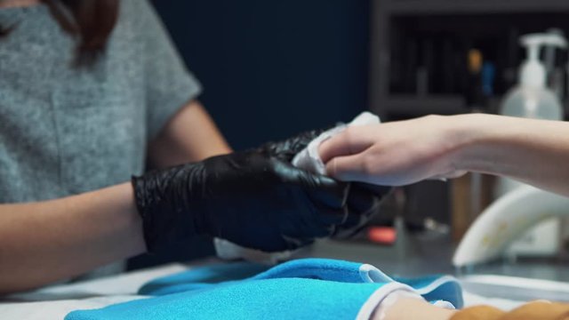 Spa Salon. Manicure. Paraffin Hand Bath. process paraffin treatment. Bowl, additive. Wax bathtub Care. Nail care. Nail artist doing manicure. Professional master putting mitten on hand customer