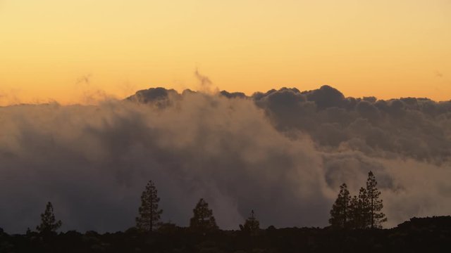 Observing the picturesque skyscape from the mountain at sunset. Heap clouds dissolving in the air. Nature scene of Teide National Park on Tenerife, Canary Islands