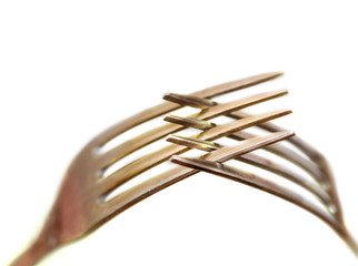 metal forks inserted into each other. white background