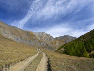 dirt road leads to the peaks of the mountains