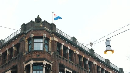 beautiful brown building corner and waving Netherlands flag - Powered by Adobe