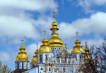 Fototapeta na wymiar Orthodox Christian Cathedral with golden domes and crosses against the sky, spring day