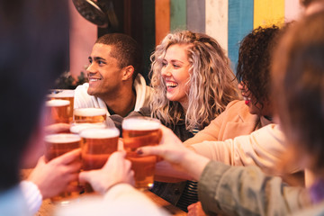 Friends drinking and toasting with beer at pub