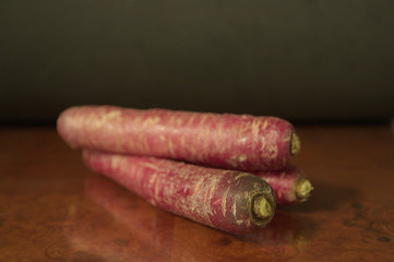 Image of some purple carrots on dark background. dark food