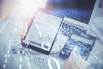 Double exposure of man's hand holding and using a digital device and data theme hologram drawing. Technology concept.