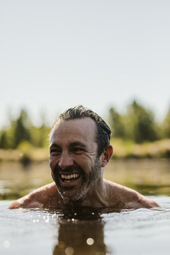 Smiling Mature Man Swimming In A Lake