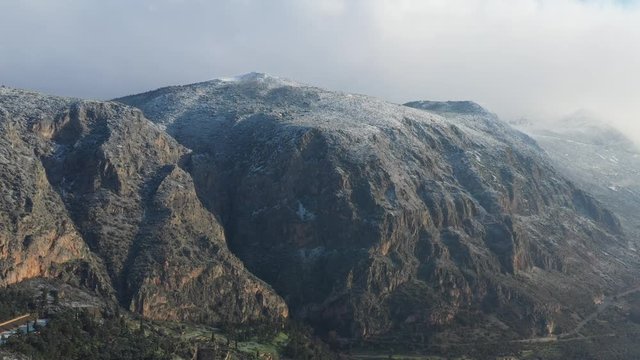 Aerial view of antique Theatre and Apollo Temple in Delphi, Greece at sunrise, famous archaeological site in Greece, Morning fog over mountains, hoarfrost on roofs