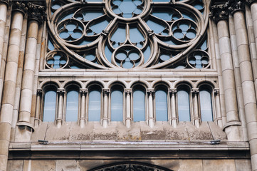 Round window with stained glass on facade of the building. Baroque and Gothic architecture. Church of St. Olga and Elizabeth. Lviv, Ukraine.