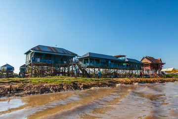 Kampong Phluk Floating Village on the Tonle Sap lake near Siem Reap, Cambodia during sunset. The Stilt houses of the floating town during low tide. Exotic places at South East Asia