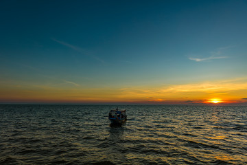 Sunset at Tonle Sap Lake, Cambodia, near the Kampong Phluk Floating Village and Siem Reap. Tourism boats cruising on the water to enjoy the breathtaking colorful sunset. Sunset horizon over the sea.