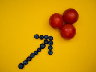 arrow made with blueberries pointing to some fresh tomatoes