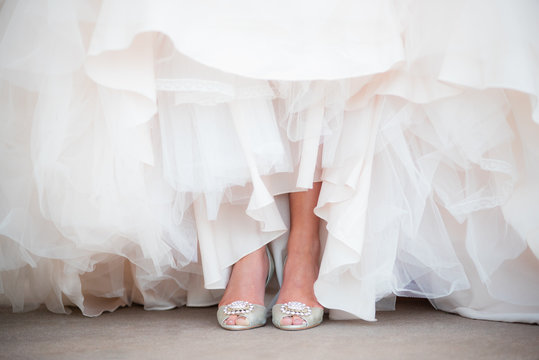 View of a brides shoes in among layers of tulle ruffles