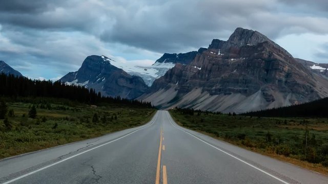 Cinemagraph Continuous Loop Animation. Scenic road in the Canadian Rockies during a vibrant sunny and cloudy summer morning. Taken in Icefields Parkway, Banff National Park, Alberta, Canada.