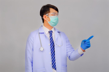 Medical doctor in white uniform doctor wears medical gloves, medical masks and and wearing protective glasses shows his hand to the camera on gray background, corona virus concept, covid19 concept