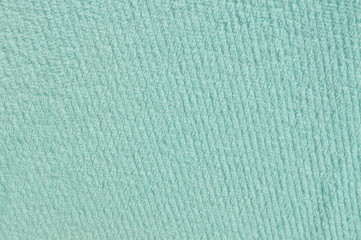 The patterned surface of the light blue fabric is placed outdoors.