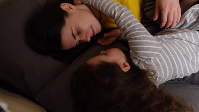 Happy young mother and cute little kid girl hugging bonding in children's room in tent, adorable small child daughter embrace kiss loving foster care parent mum cuddling enjoy tenderness concept