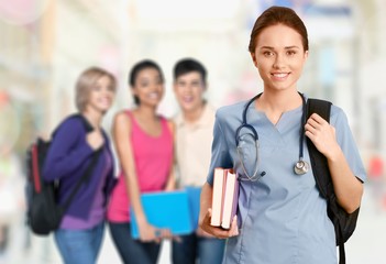 Nurse student with books and stethoscope on the groop of students background