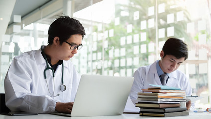 Cropped shot view of Medical staff working at the hospital doctor and nurse checking a patient's medical record on a clipboard, healthcare and medical Close-up medical worker typing on laptop