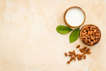 Obraz na płótnie Canvas Almond milk near nuts on beige background top-down copy space