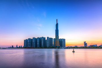 Colorful sunset landscape in a riverside urban area with skyscrapers showing the most economic development in Ho Chi Minh City, Vietnam