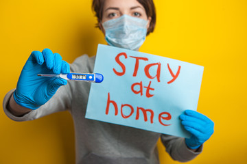 woman in a medical mask with a temperature. Holding a thermometer in his hands. mild condition of a coronavirus patient. Stay home until the doctor arrives. Distribution of covid-19