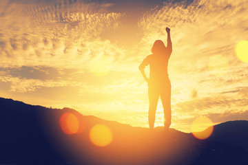 Copy space of woman rise hand up on top of mountain and sunset sky abstract background.