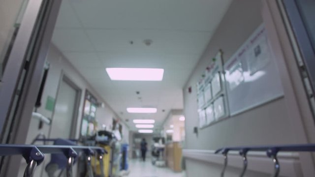 Point of View (POV) of Patient on Emergency Room Stretcher / Gurney being pushed through Emergency Room doorway and then being pushed down Hospital Emergency Room hallway. Slow Motion - 4K UHD