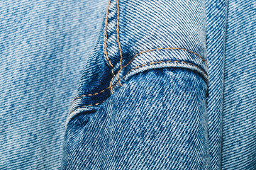 Jeans background with seams. denim texture close up. fabric backdrop