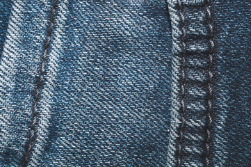 Jeans background with seams. denim texture close up. fabric backdrop