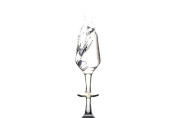 Ice cubes splashing into wine glass of water, isolated on white